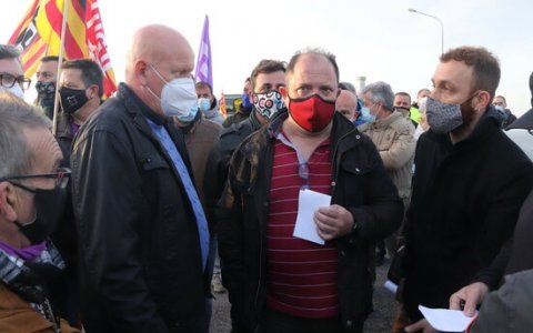 El cap de producció d'Iqoxe (esquerra) parla amb els treballadors després d'haver-los entregat la carta prequè entressin a cobrir els serveis mínims. FOTO: ACN.
