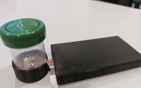 L'aparell desenvolupat en la recerca i el mòbil que llegeix les dades emeses pel sensor.