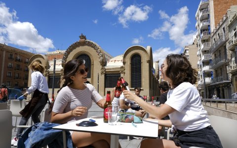 Dues noies briden amb una cervesa en una terrassa de la plaça del Mercat de Tarragona. FOTO: XAVI JURIO.